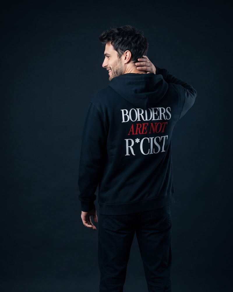 Mann trägt die WORN OPINIONS Kapuzenjacke Borders are not in Schwarz von hinten, Rückenprint Borders are not R*cist
