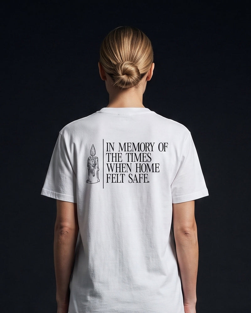 Frau trägt das WORN OPINIONS T-Shirt In memory of the times in Weiß von hinten, Rückenprint In memory of the times when home felt safe mit Kerzen-Illustration