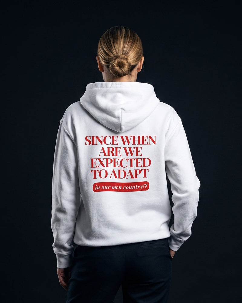 Frau trägt den WORN OPINIONS Hoodie Since when are we expected to adapt in Weiß von hinten, Rückenprint Since when are we expected to adapt, in our own country!?