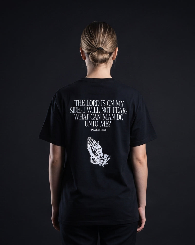 Frau trägt das WORN OPINIONS T-Shirt The Lord is on my side in Schwarz von hinten, Rückenprint Psalm 118:6 mit betenden Händen
