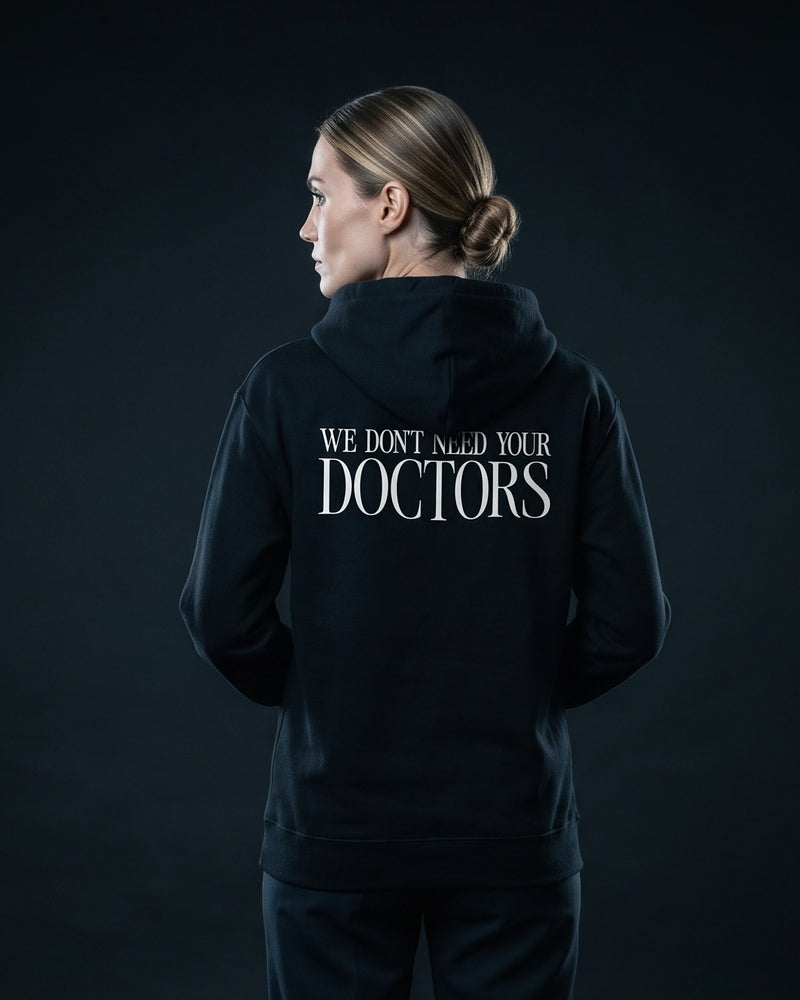 Frau traegt schwarzen Hoodie mit Rueckenprint "We don't need your Doctors"