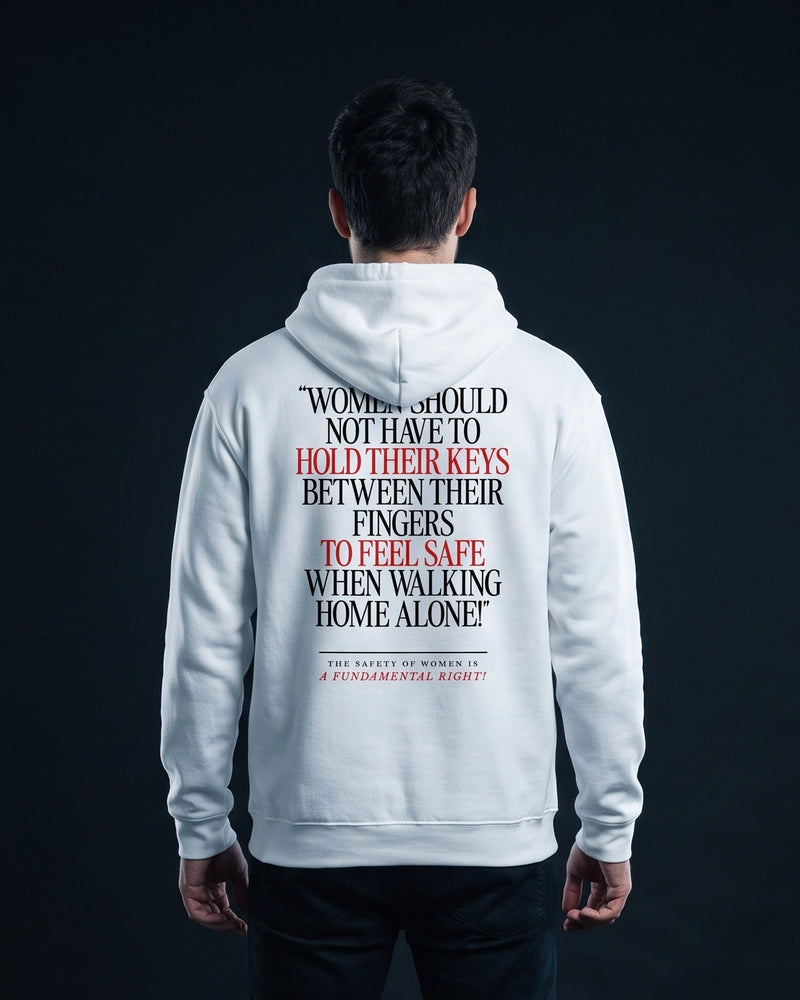 Mann trägt den WORN OPINIONS Hoodie Women should not have to hold their keys between their fingers in Weiß von hinten, Rückenprint „Women should not have to hold their keys between their fingers to feel safe when walking home alone!“ – The safety of women is a fundamental right!