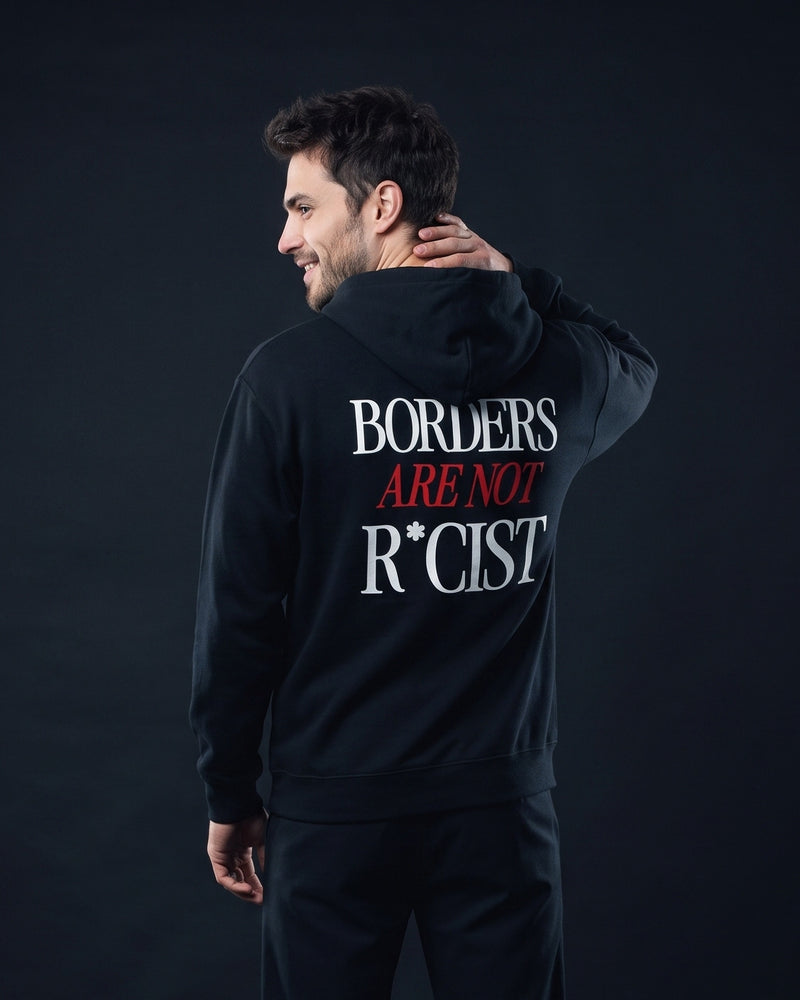 Mann trägt den WORN OPINIONS Hoodie Borders are not in Schwarz von hinten, Rückenprint Borders are not R*cist