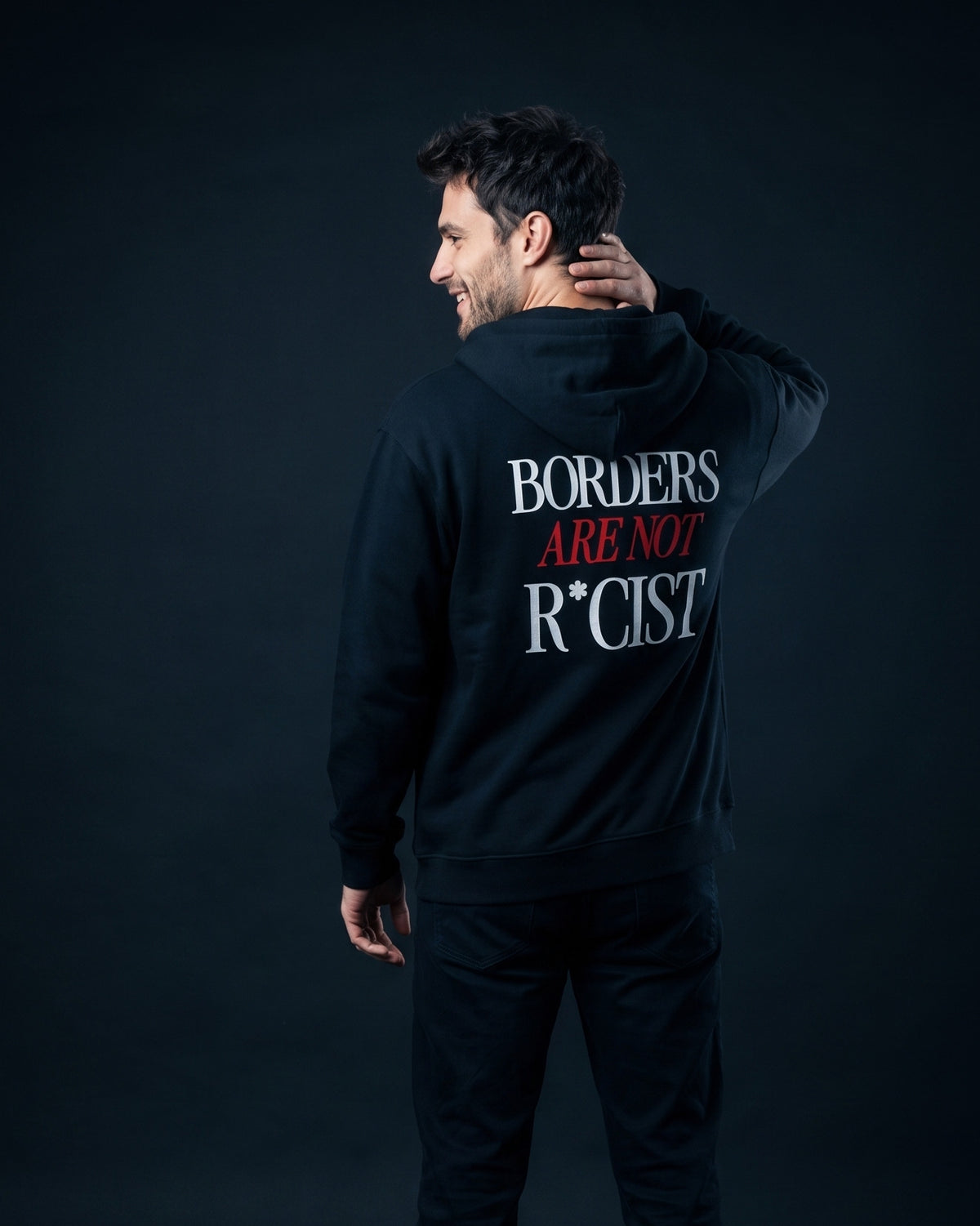 Mann trägt die WORN OPINIONS Kapuzenjacke Borders are not in Schwarz von hinten, Rückenprint Borders are not R*cist