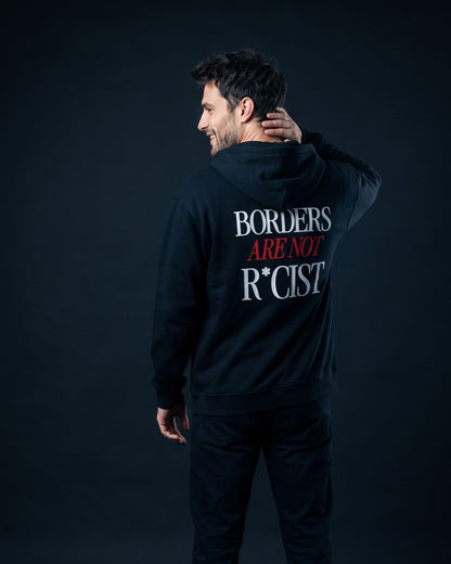Mann trägt die WORN OPINIONS Kapuzenjacke Borders are not in Schwarz von hinten, Rückenprint Borders are not R*cist
