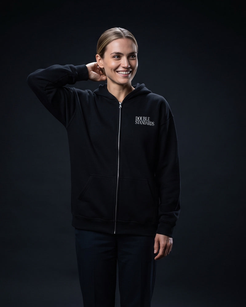 Frau trägt schwarzen Zip-Hoodie mit kleinem Brustprint "Double Standards"
