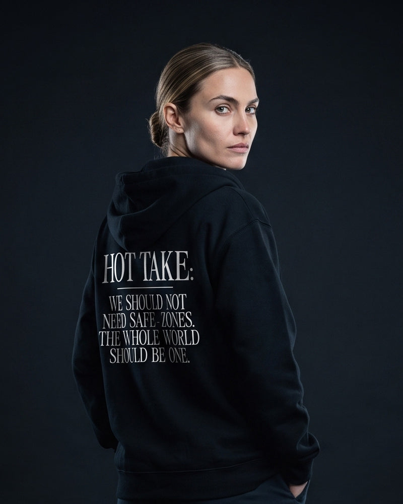 Frau in schwarzem Zip-Hoodie mit dem Rueckenprint 'Hot Take: We should not need safe-zones. The whole world should be one.'