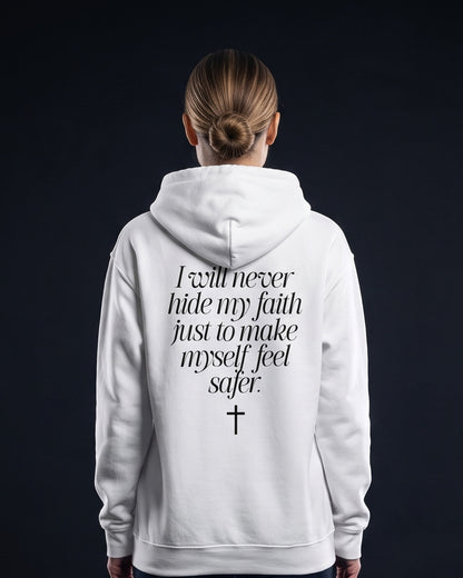 Frau trägt weißen Hoodie mit dem Rücken-Print "I will never hide my faith just to make myself feel safer." und einem Kreuz-Symbol darunter