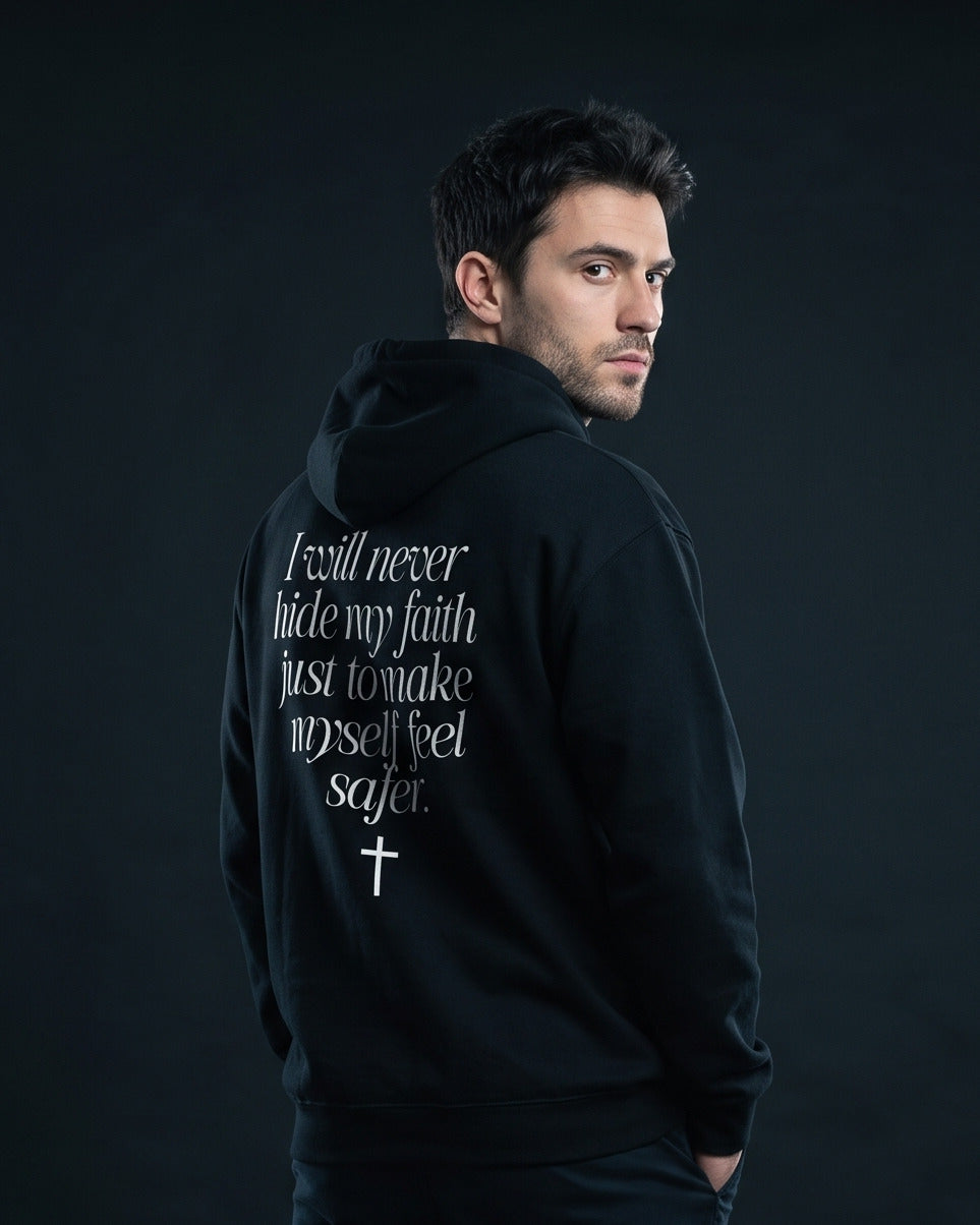 Mann trägt schwarzen Hoodie mit dem Rücken-Print "I will never hide my faith just to make myself feel safer." und einem Kreuz-Symbol darunter