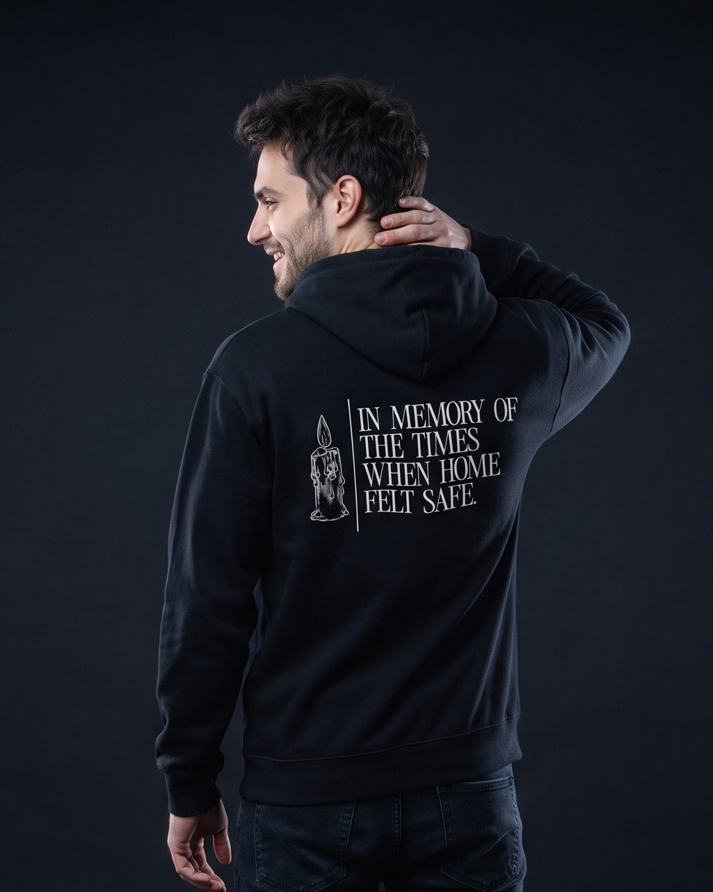 Mann trägt den WORN OPINIONS Hoodie In memory of the times in Schwarz von hinten, Rückenprint In memory of the times when home felt safe mit Kerzen-Illustration