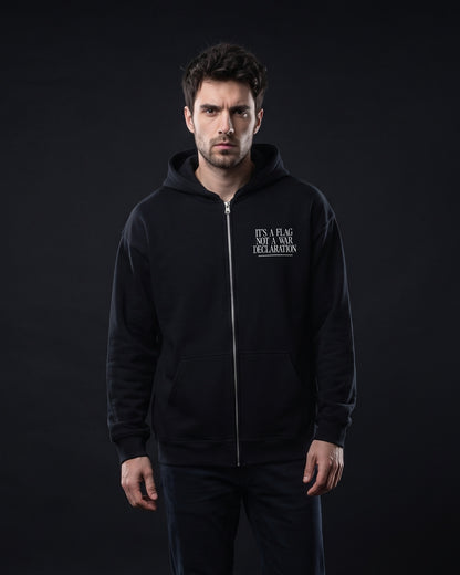 Mann trägt schwarzen Zip-Hoodie mit kleinem Brustprint "It's a flag, not a war declaration"
