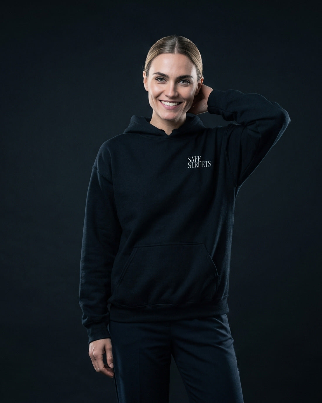 Frau trägt den WORN OPINIONS Hoodie Safe Streets in Schwarz von vorn, Brustprint Safe Streets