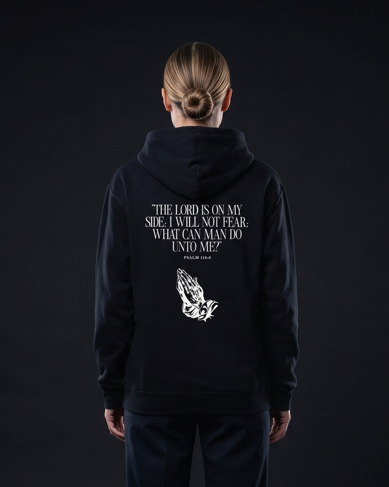 Frau trägt den WORN OPINIONS Hoodie The Lord is on my side in Schwarz von hinten, Rückenprint Psalm 118:6 mit betenden Händen