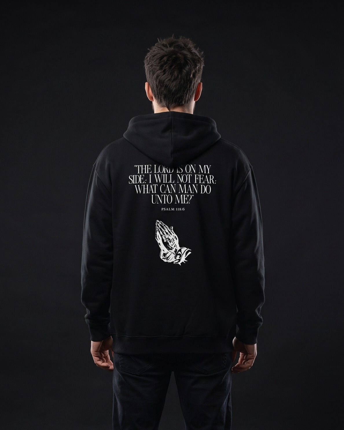 Mann traegt schwarzen Zip-Hoodie mit Rueckendruck "The Lord is on my side; I will not fear; what can man do unto me?", Psalm 118:6, und Grafik betender Haende