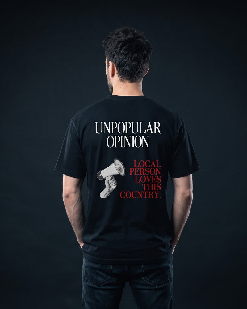 Mann im schwarzen T-Shirt mit Rueckenprint 'Unpopular Opinion - Local Person loves this Country'