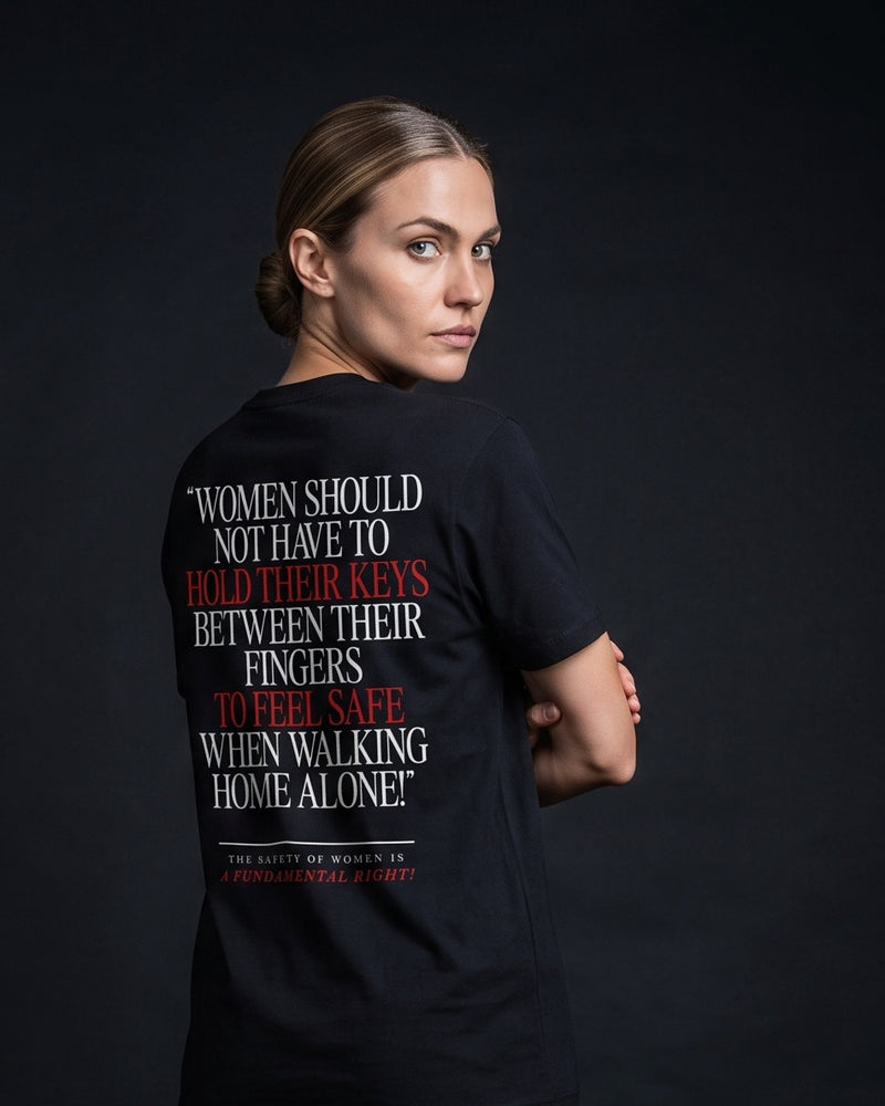Frau trägt das WORN OPINIONS T-Shirt Women should not have to hold their keys between their fingers in Schwarz von hinten, Rückenprint mit dem Statement und der Zusatzzeile The safety of women is a fundamental right