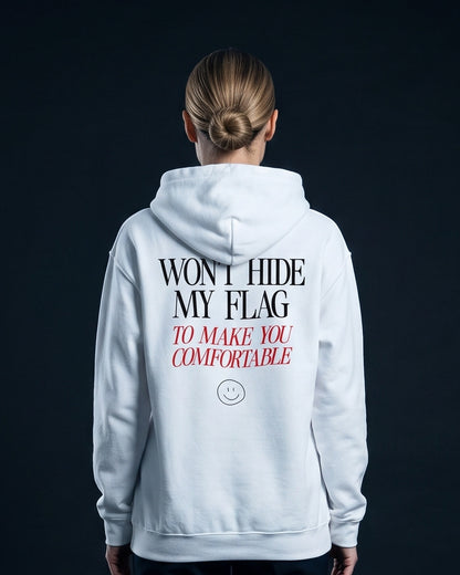 Frau von hinten in weissem Hoodie mit dem Aufdruck "WON'T HIDE MY FLAG" und darunter kursiv-rot "TO MAKE YOU COMFORTABLE" samt kleinem Smiley-Icon.